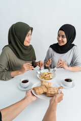 attractive hijab woman breakfasting eating some ketupat or rice cake dish