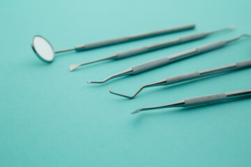 Professional Dentist tools in dental office: dentist mirror, forceps curved, explorer curved, dental explorer angular and explorer curved with chip, right. Dental Hygiene and Health conceptual image.