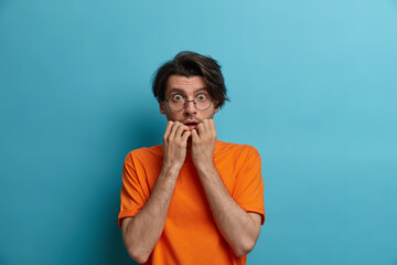 Frightened panicking man bшtes finger nails nervously being nervous about problems, suffers...