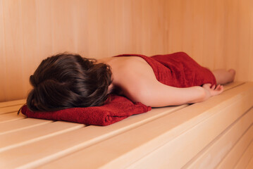 Beautiful woman relaxing in sauna and staying healthy