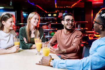 Two happy multi-ethnic guys discussing curious moments of the last bowling game