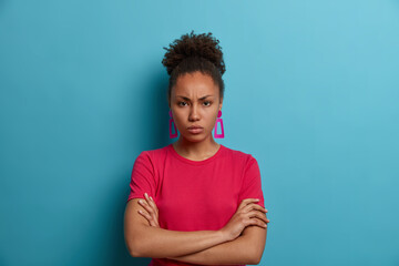 Offended angry African American woman has bad mood, frowns face and stands distressed, being...