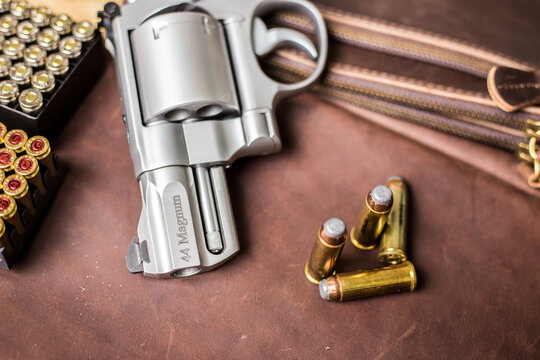 .44 magnum concel gun with bullet on leather background