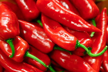 a pile of vegetables red hot chili peppers as background