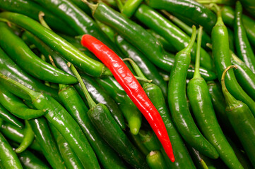 vegetables one red and pile green hot chili peppers as background