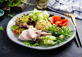 Ketogenic diet. Dinner dish with boiled pork meat, avocado guacamole, tomatoes, cucumbers, mozzarella cheese, black olives  and arugula. Detox and healthy concept. Keto food.