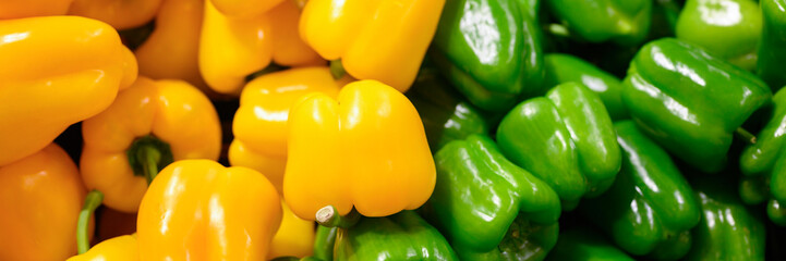 a pile of vegetables green and yellow sweet bell peppers as background. banner