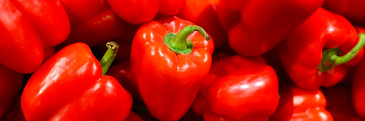 a pile of vegetables red sweet bell peppers as background. banner