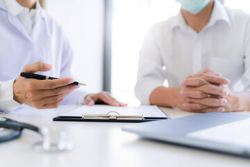 Fototapeta premium Medical doctor taking notes with patient in clinic.
