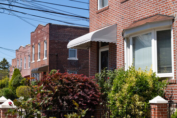 Row of Old Brick Homes with Beautiful Spring Gardens in Astoria Queens New York