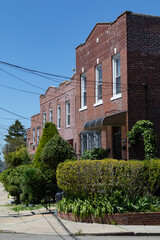 Row of Old Brick Homes with Beautiful Spring Gardens in Astoria Queens New York