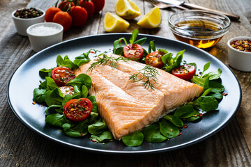 Steamed salmon fillet with vegetables on wooden table