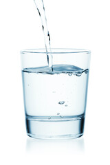 Water is poured into a glass of water. Isolated on a white background.