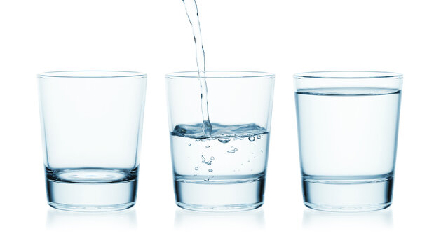 Water is poured into a glass of water. Next to it is an empty and full glass of water. Isolated on a white background.