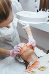 Obraz na płótnie Canvas Close-up beautician doctor hand making anti-age procedure.