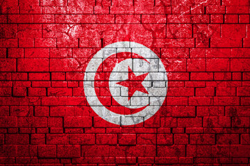 National flag of Tunisia on brick  wall background.The concept of national pride and symbol of the...