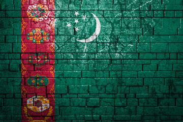 National flag of Turkmenistan on brick  wall background.The concept of national pride and symbol of the country. Flag  banner on  stone texture background.