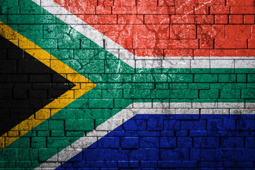 National flag of South African Republic on brick  wall background.The concept of national pride and symbol of the country. Flag  banner on  stone texture background.