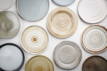 Empty homemade pottery plates on white background. Top view