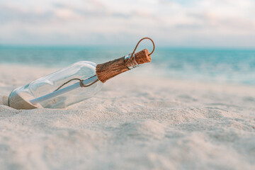 Message in the bottle washed ashore against the sun setting down. Tropical beach sea shore castaway...