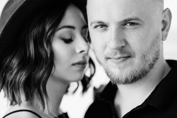 young couple a guy with a girl in black clothes are walking on the white sand