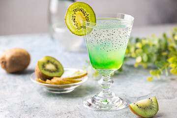 Cold cocktail kiwi drink in a glass with fresh fruits on gray background