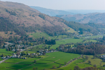 Fototapeta na wymiar Grasmere village, Fairfield horseshoe and Loughrigg Fell in the background, seen from the summit of Helm Crag, Grasmere, Lake District, Cumbria, UK