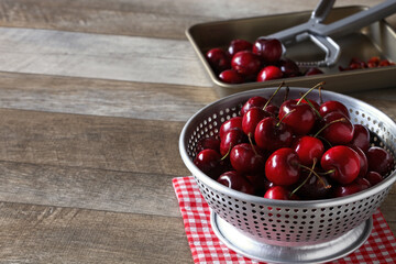 removing pitts from cherries in colander, copy space