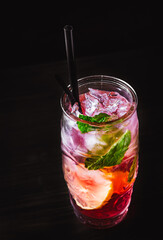 Glass of Refreshing Watermelon lemonade With Ice on black wooden table background