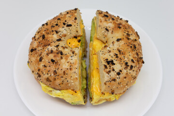 Everything Bagel with Avocado Eggs and Cheese on a White Plate