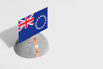 Cook Islands flag tagged on rounded stone. White isolated background. Side view minimal national...
