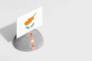 Cyprus flag tagged on rounded stone. White isolated background. Side view minimal national concept.
