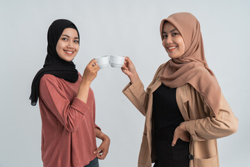 two friend hijab with coffee cup smiling to camera