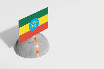 Ethiopia flag tagged on rounded stone. White isolated background. Side view minimal national...