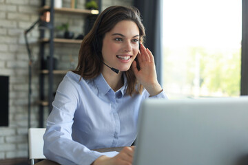 Female customer support operator with headset and smiling.