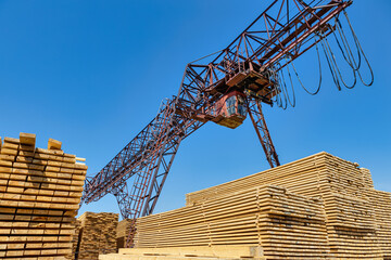 Industrial warehouse timber mill, finished products on a sawmill outdoors. Timber loading Gantry...