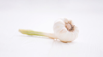 Fresh juicy garlic on the white wooden background 