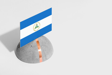 Nicaragua flag tagged on rounded stone. White isolated background. Side view minimal national...