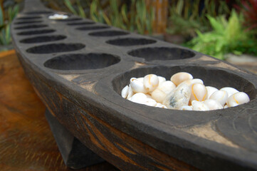 Philippine mancala sungka game consists of wooden board and seed shells