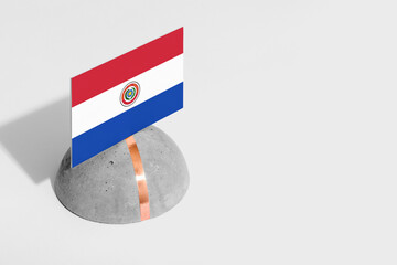 Paraguay flag tagged on rounded stone. White isolated background. Side view minimal national...
