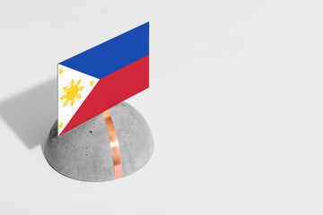Naklejka premium Philippines flag tagged on rounded stone. White isolated background. Side view minimal national concept.