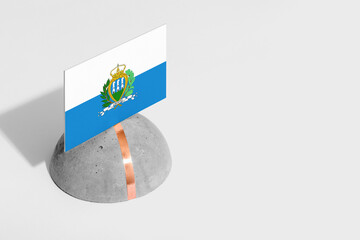 San Marino flag tagged on rounded stone. White isolated background. Side view minimal national...