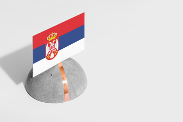 Serbia flag tagged on rounded stone. White isolated background. Side view minimal national concept.