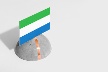 Sierra Leone flag tagged on rounded stone. White isolated background. Side view minimal national...