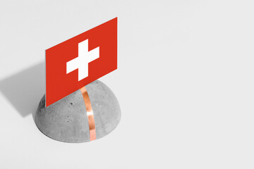Switzerland flag tagged on rounded stone. White isolated background. Side view minimal national...