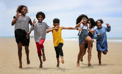 Cute kids having fun on sandy beach in summertime