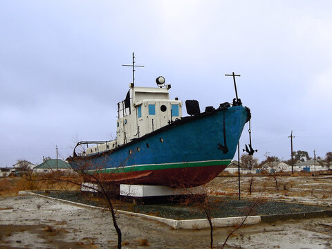 Real model of former sea boat on a pedestal as monument of passed days when Mo'ynoq was an active sea port on Aral sea. Picture taken in former piscatorial port Mo'ynoq (Moynaq) or Muynak, Uzbekistan