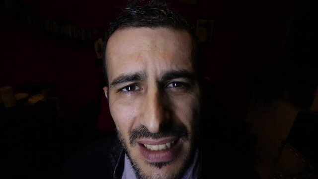 Ritratto di ragazzo moro che  parla animatamente isolato su sfondo nero