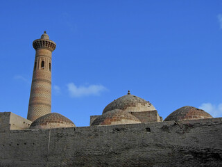 Minaret, domes & outer wall of Sayid Niaz Sheliker Mosque in Khiva, Uzbekistan. Place located...