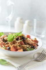 Spaghetti Pasta with Vegetables and fresh Basil on bright wooden Background.